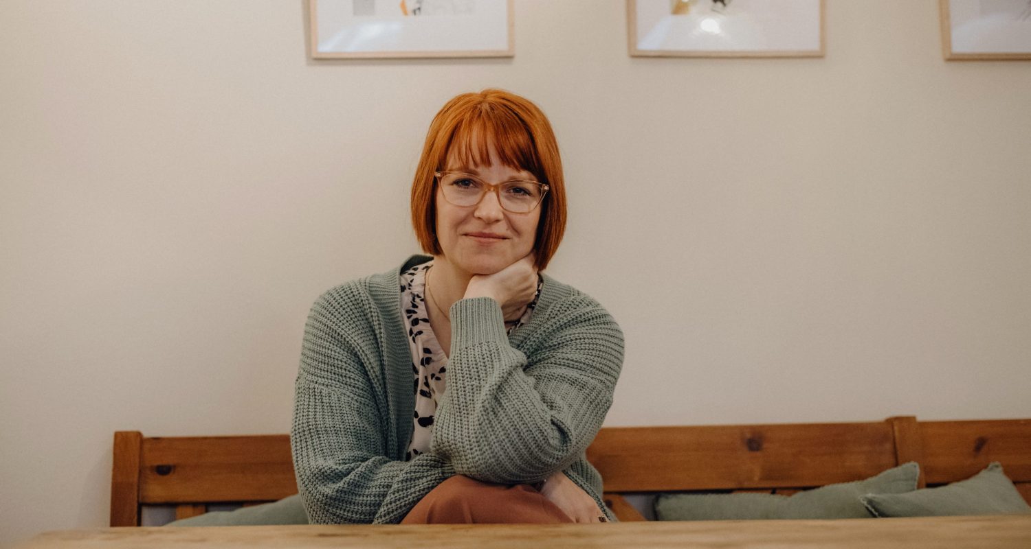 Karoline Krey, Coachin für persönliche Transformation bei marvelousme, sitzt mit ruhigem Blick und unterstützender Haltung in einem gemütlichen Coachingraum